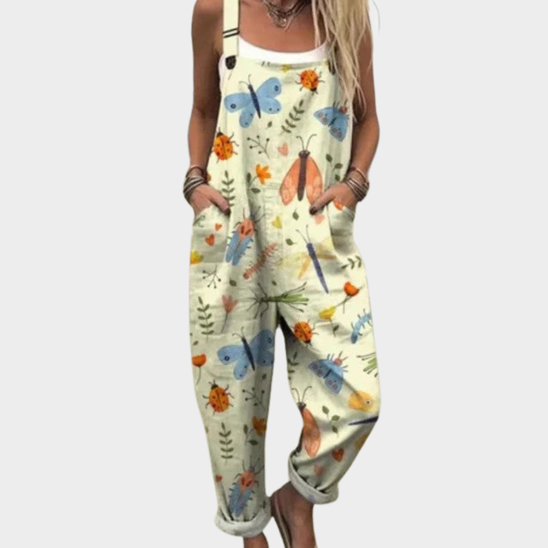 Woman wearing cream overalls printed with painterly butterflies, ladybirds and fine leafy sprigs