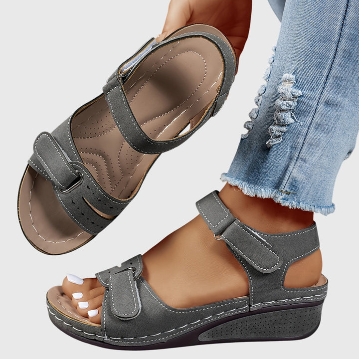 A woman wearing wide-fit supportive sandals with a relaxed summer outfit, walking with ease and confidence.