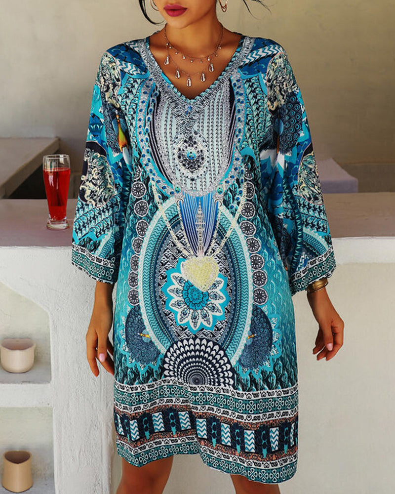 Woman wearing the Lucie boho print dress with bell sleeves, smiling outdoors on a bright day.