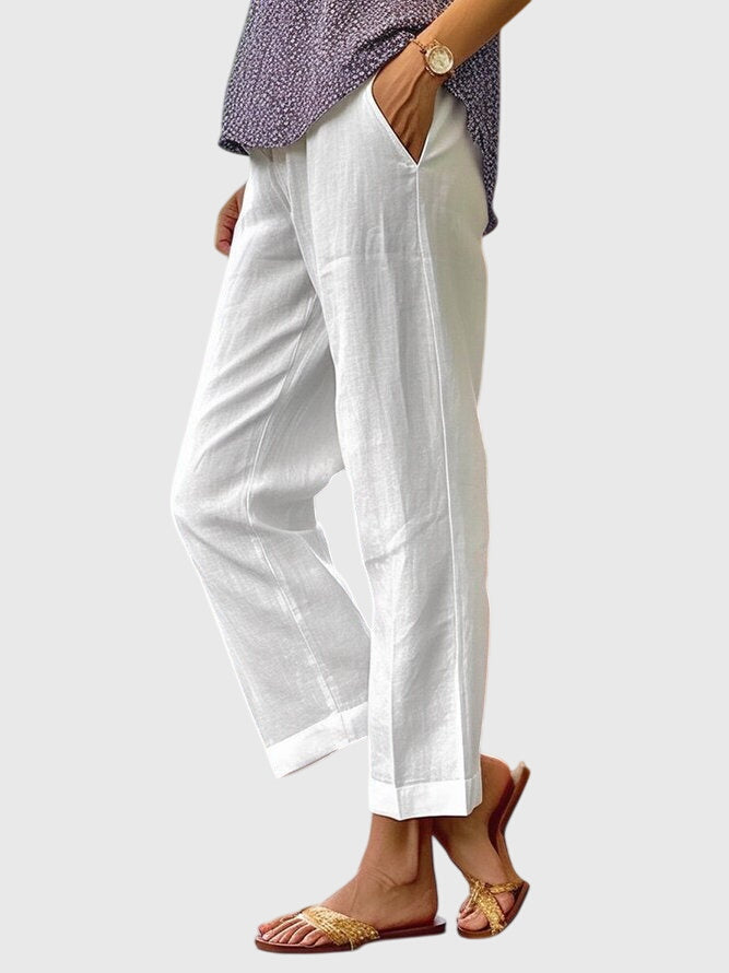 A woman wearing elegant tailored pants with a flattering straight-leg cut and clean lines.