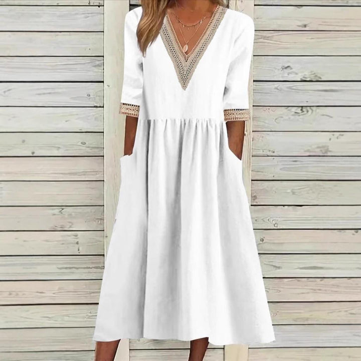 A woman wearing the Anne V-neck midi dress with delicate detailing at the collar and sleeves.