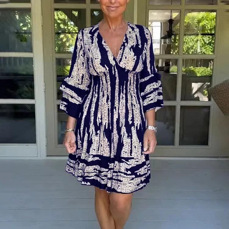 Woman wearing a boho print mini dress with ruffled sleeves and a soft V-neckline.