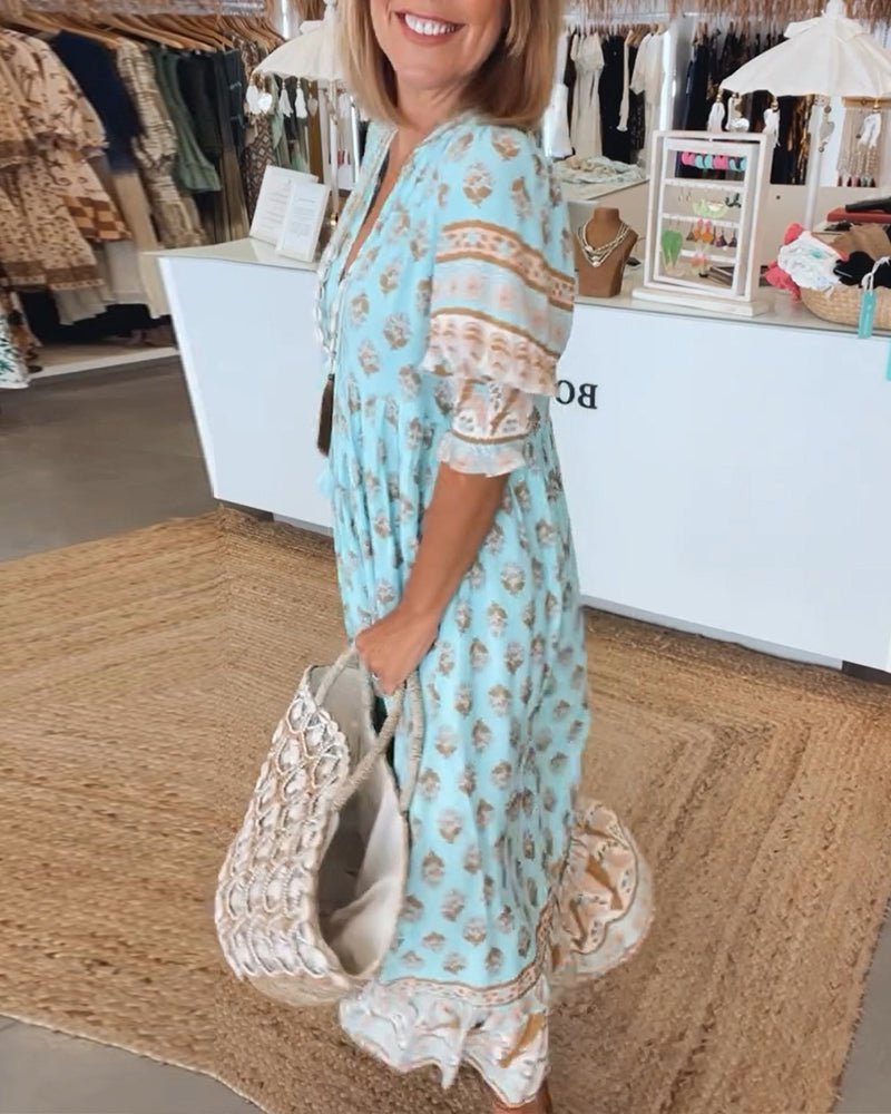 A woman wearing the Tracy boho floral midi dress with a fringed neckline and ruffled skirt.