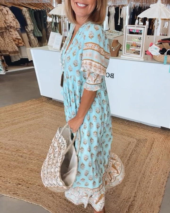 A woman wearing the Tracy boho floral midi dress with a fringed neckline and ruffled skirt.