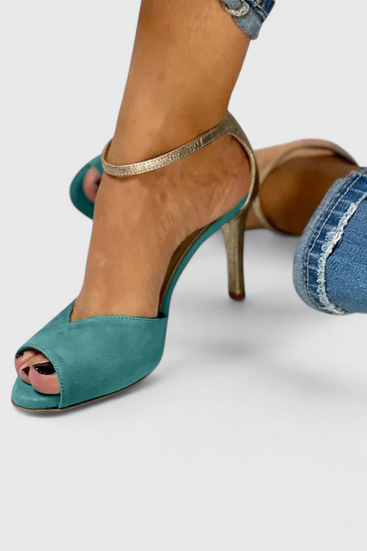 A woman wearing green open-toe heels, standing out in a striking occasion outfit.
