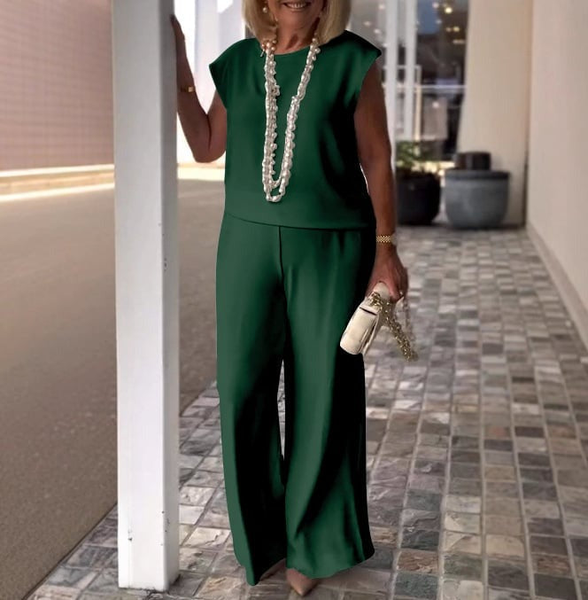 A woman wearing a flowing short-sleeve top with graceful wide-leg pants.