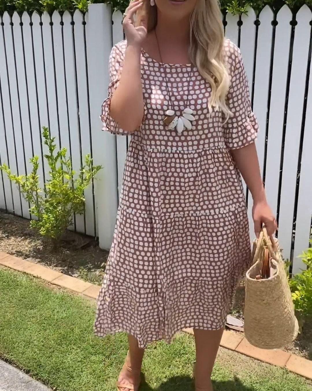 Woman wearing the Natalie™ polka dot midi dress with short sleeves, relaxed and smiling in a summer setting.