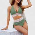 A woman wearing an elegant matching bikini set with a bold print, relaxed and confident on the beach.