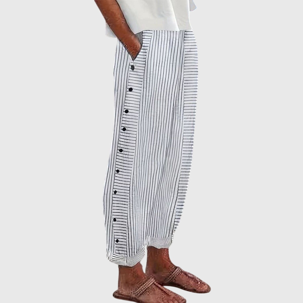 A woman wearing elegant everyday pants in a fine blue stripe with a wide cut and side buttons.