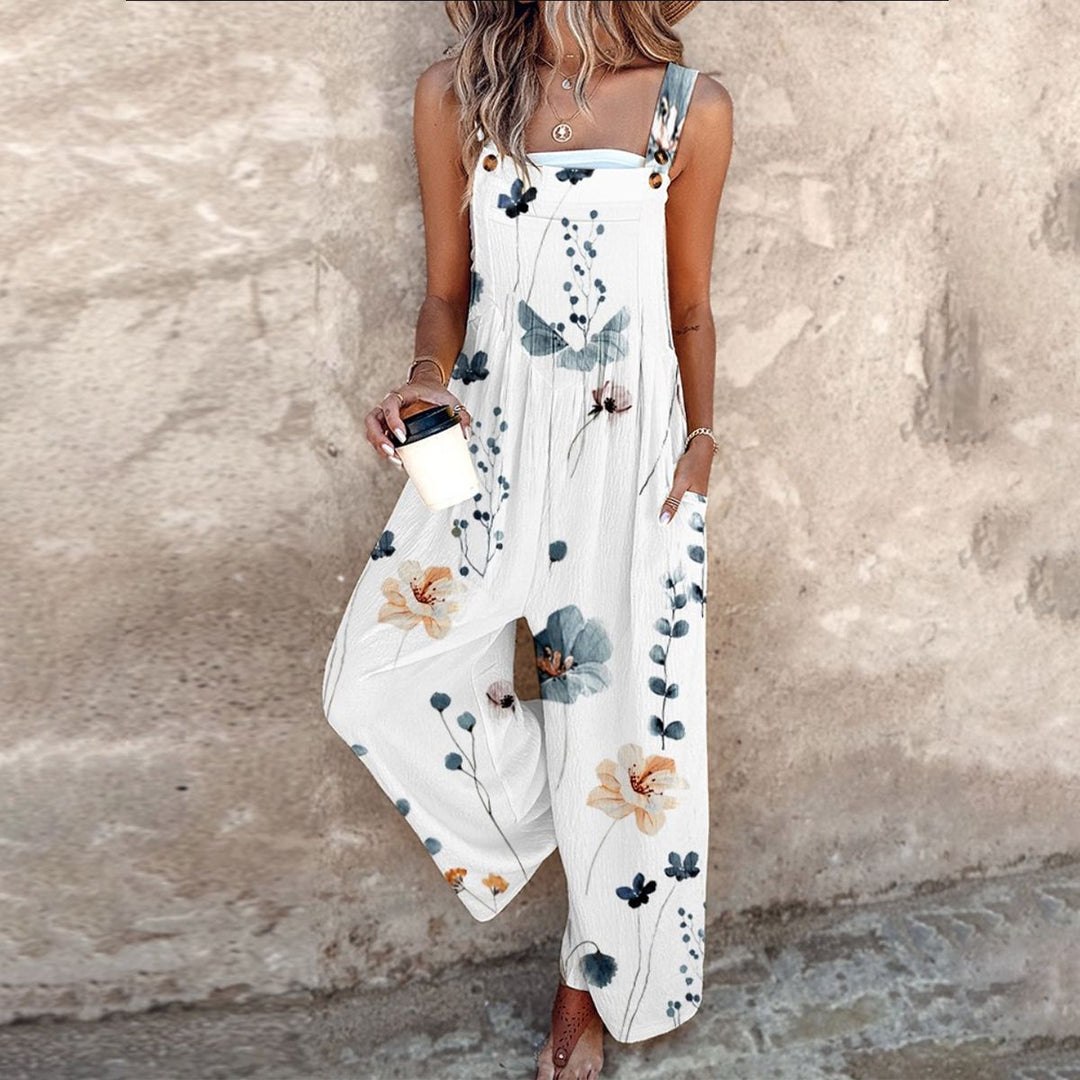 A woman wearing elegant black overalls with a single large cream bloom and adjustable straps.