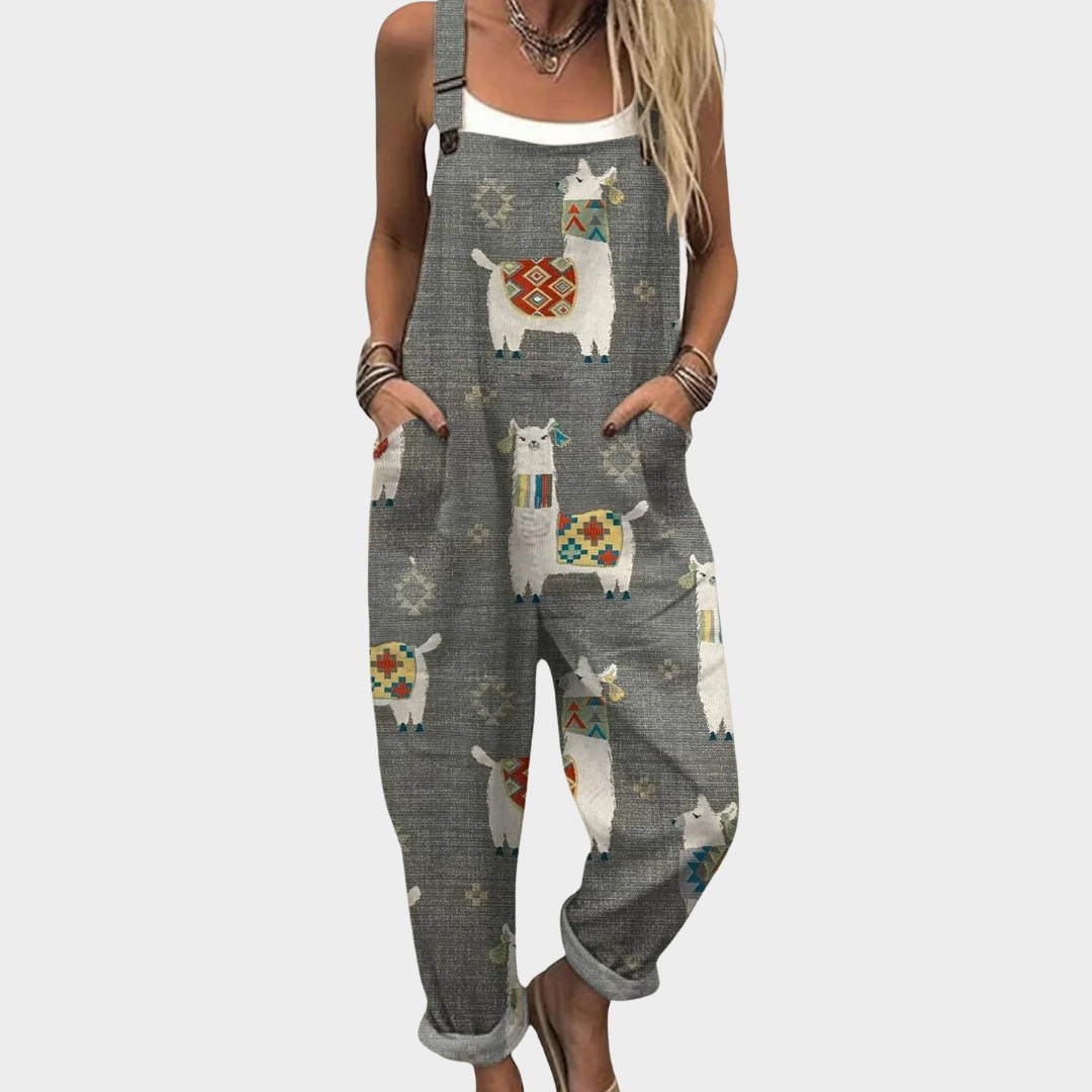 Woman wearing soft grey overalls with a playful colourful llama print and adjustable straps