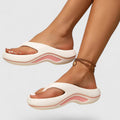 A woman in white slip-on sandals stepping out lightly, feet cushioned and supported.