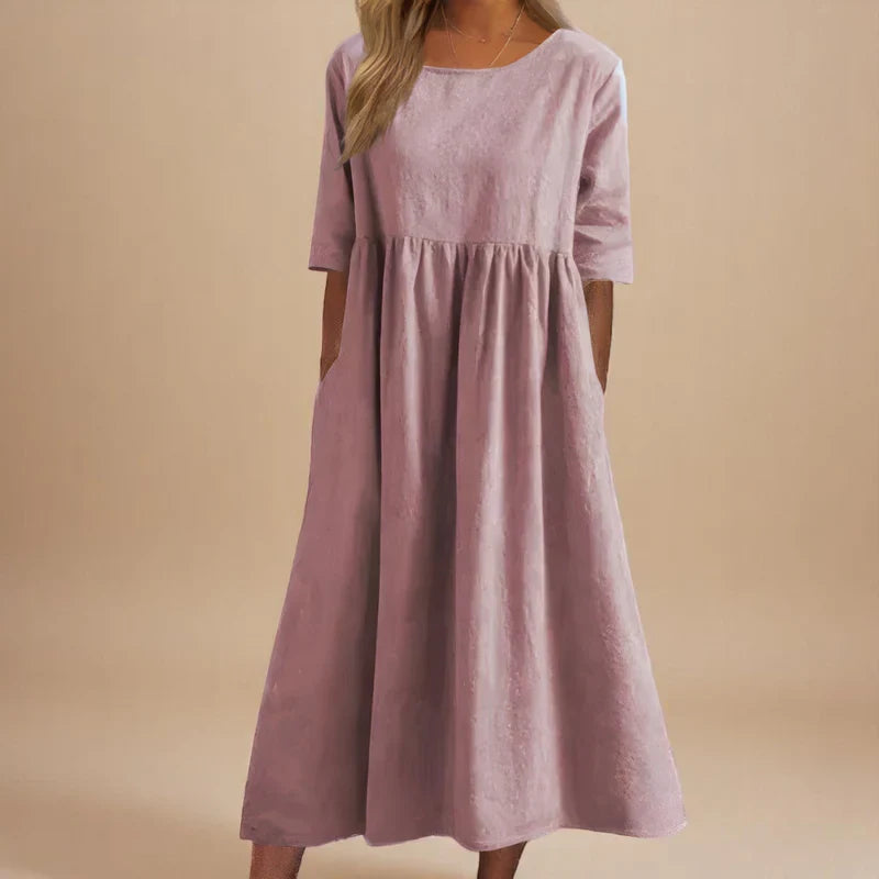 A woman wearing the Shannon flowing day dress with a gathered waist and elbow-length sleeves.