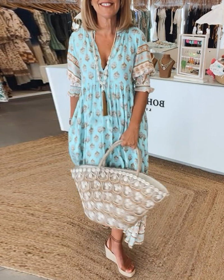 A woman wearing the Tracy boho floral midi dress with a fringed neckline and ruffled skirt.