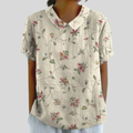 A woman wearing a floral shirt with a polo collar, comfortable and put together for the day ahead.