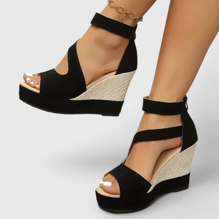 A woman walking gracefully in wide-fit wedge sandals with adjustable supportive straps.