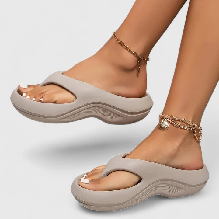 A woman in white slip-on sandals stepping out lightly, feet cushioned and supported.