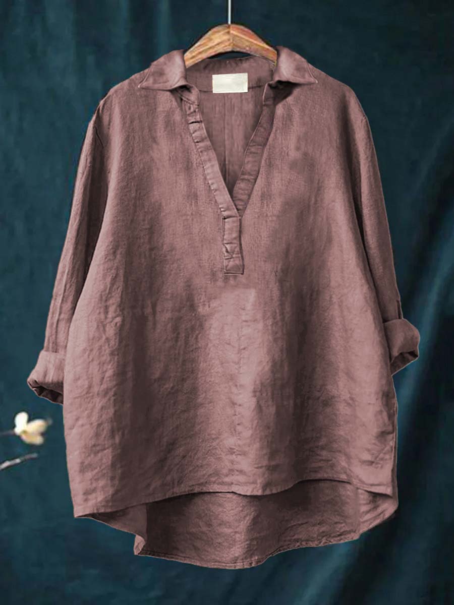 A woman wearing an elegant solid-colour summer blouse with an open V-neck, looking fresh and stylish on a warm day.