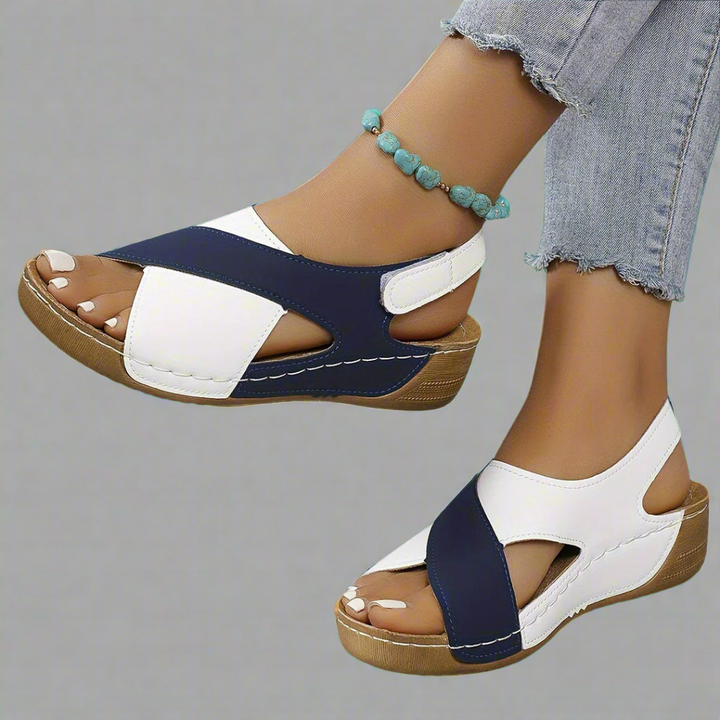 A woman walking outdoors in modern colourblock orthopaedic sandals with adjustable straps.