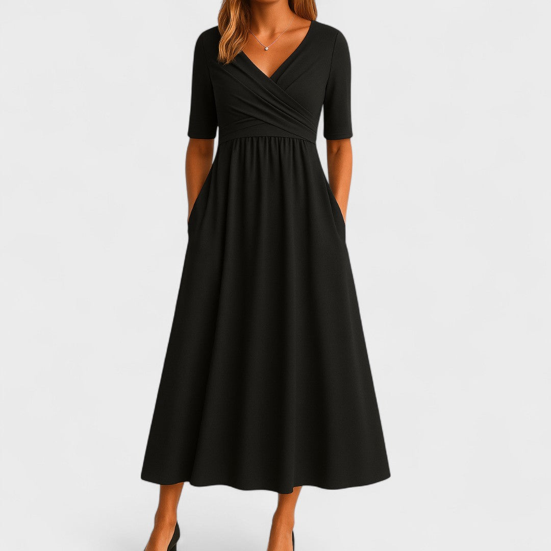 Woman wearing a royal blue mid-calf wrap dress with a crossover V-neckline, gathered waist, short sleeves and a gently flared skirt.