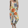 A woman wearing overalls in a lush multicolour floral print of orange, blue and green blooms.