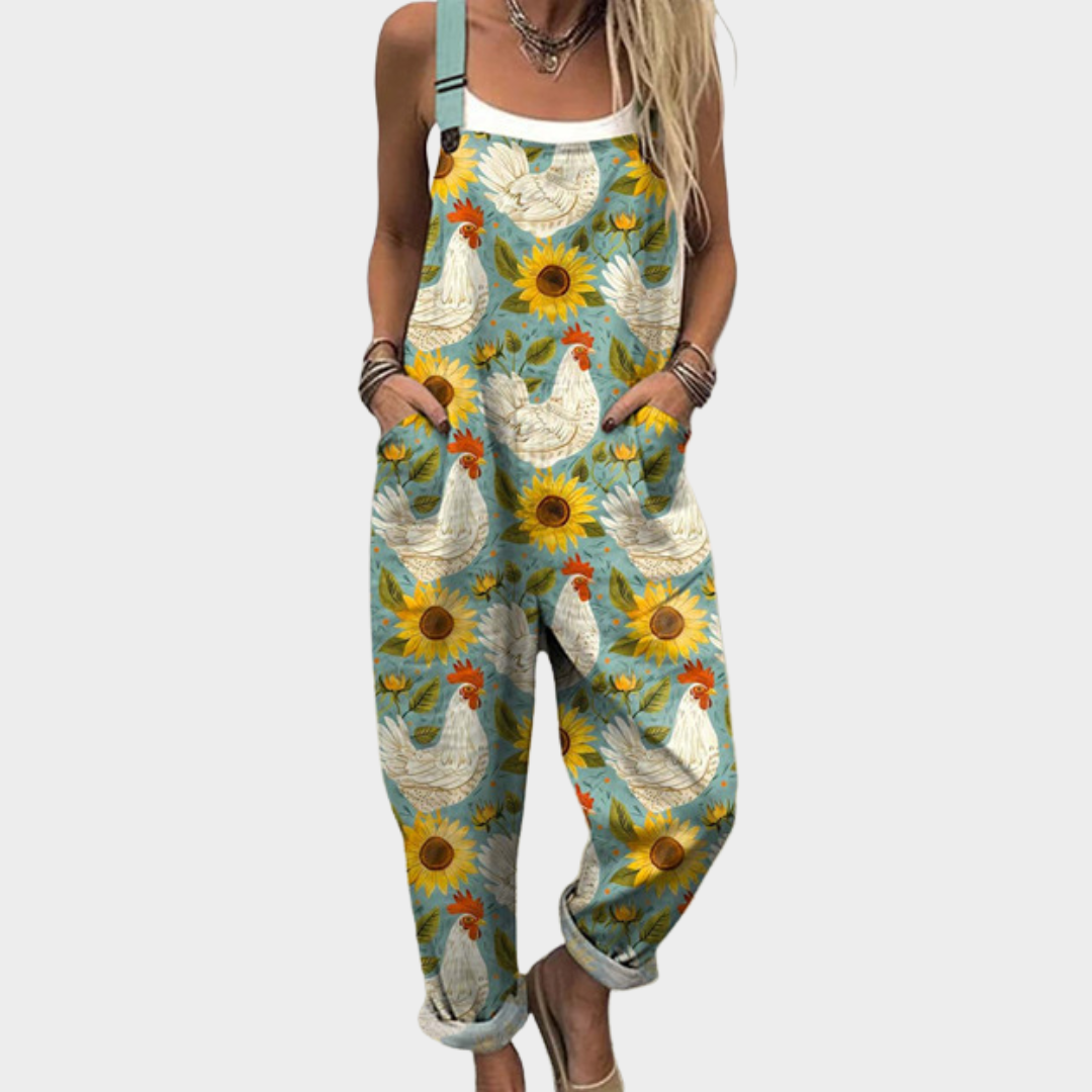 Woman wearing soft green overalls printed with bright sunflowers and white hens