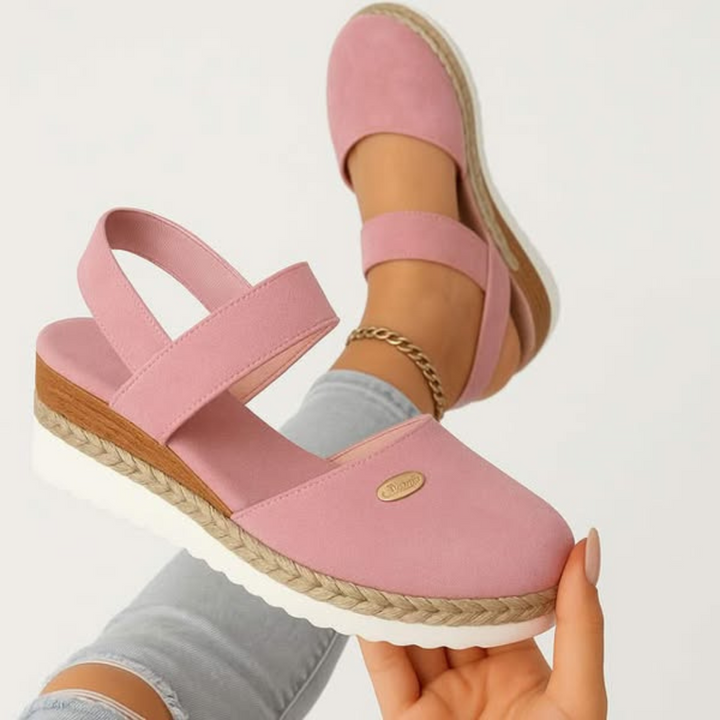 Black closed-toe wedge espadrilles with a wide stretch strap and a braided-trim platform wedge.