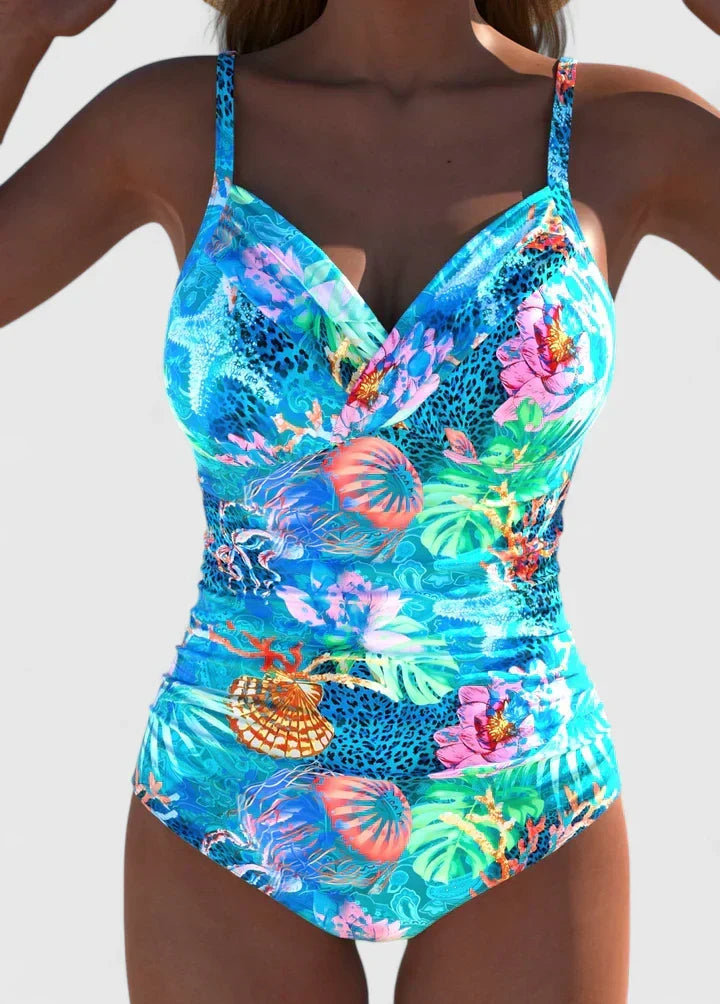 A woman wearing an elegant swimsuit with a fresh print, confident and relaxed by the water.