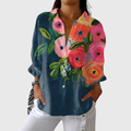 A woman wearing a light, colourful printed blouse with a relaxed, flowing cut, looking cheerful and comfortable.