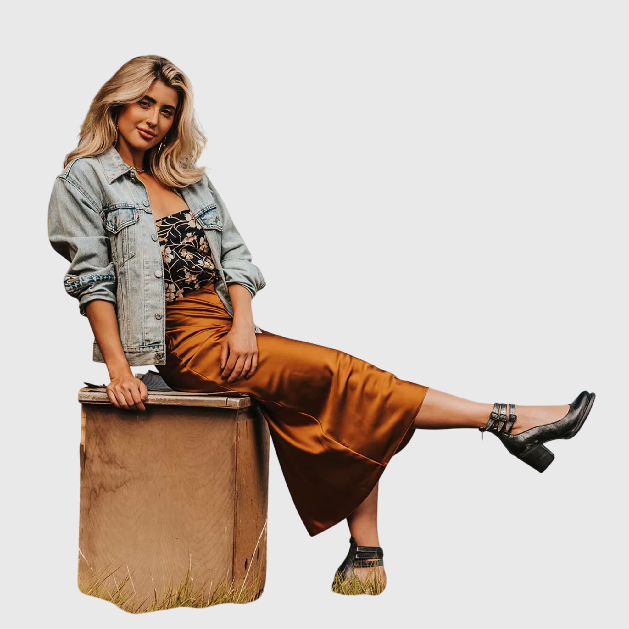 A woman wearing tan block-heel court shoes with buckled ankle straps, walking gracefully in a refined outfit.