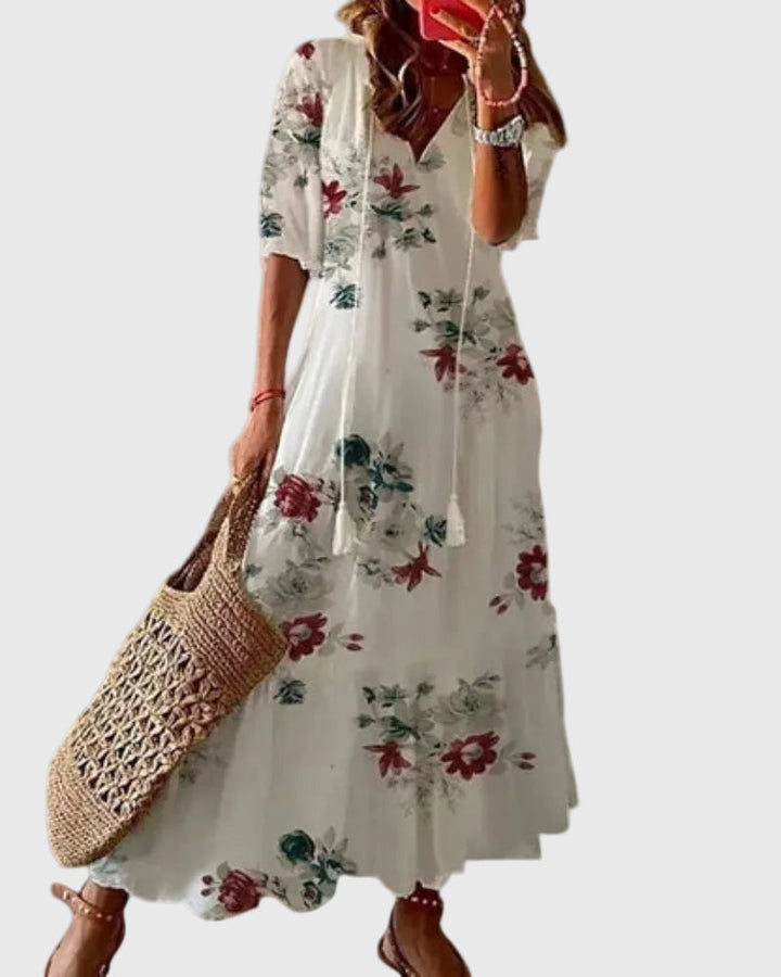 Woman wearing a long vintage-style boho maxi dress with delicate patterns and a fluttering V-neckline.