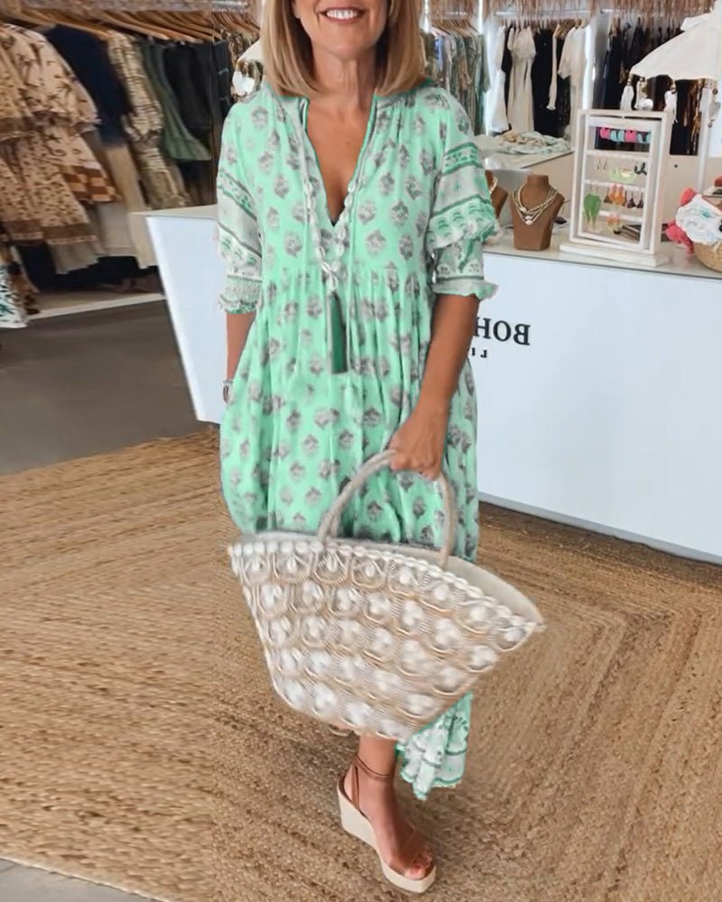 A woman wearing the Tracy boho floral midi dress with a fringed neckline and ruffled skirt.