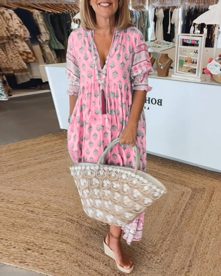 A woman wearing the Tracy boho floral midi dress with a fringed neckline and ruffled skirt.