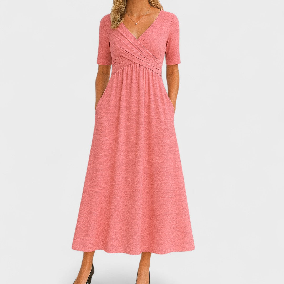 Woman wearing a royal blue mid-calf wrap dress with a crossover V-neckline, gathered waist, short sleeves and a gently flared skirt.