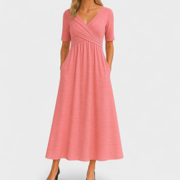 Woman wearing a royal blue mid-calf wrap dress with a crossover V-neckline, gathered waist, short sleeves and a gently flared skirt.