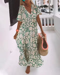 Woman wearing a flowing floral midi dress with a V-neckline while walking outdoors.