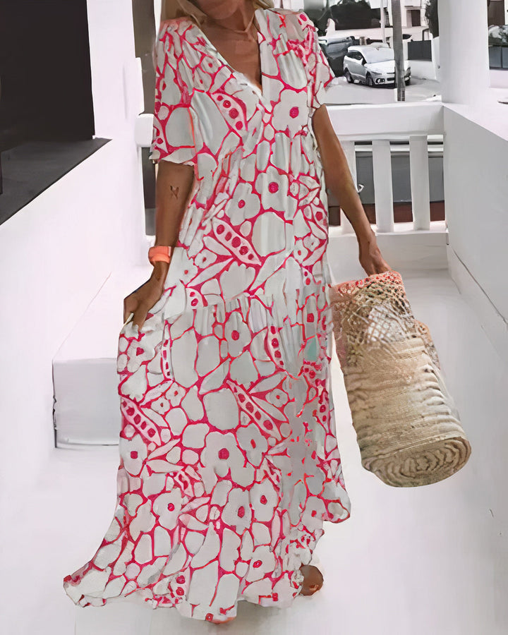 Woman wearing a flowing floral midi dress with a V-neckline while walking outdoors.