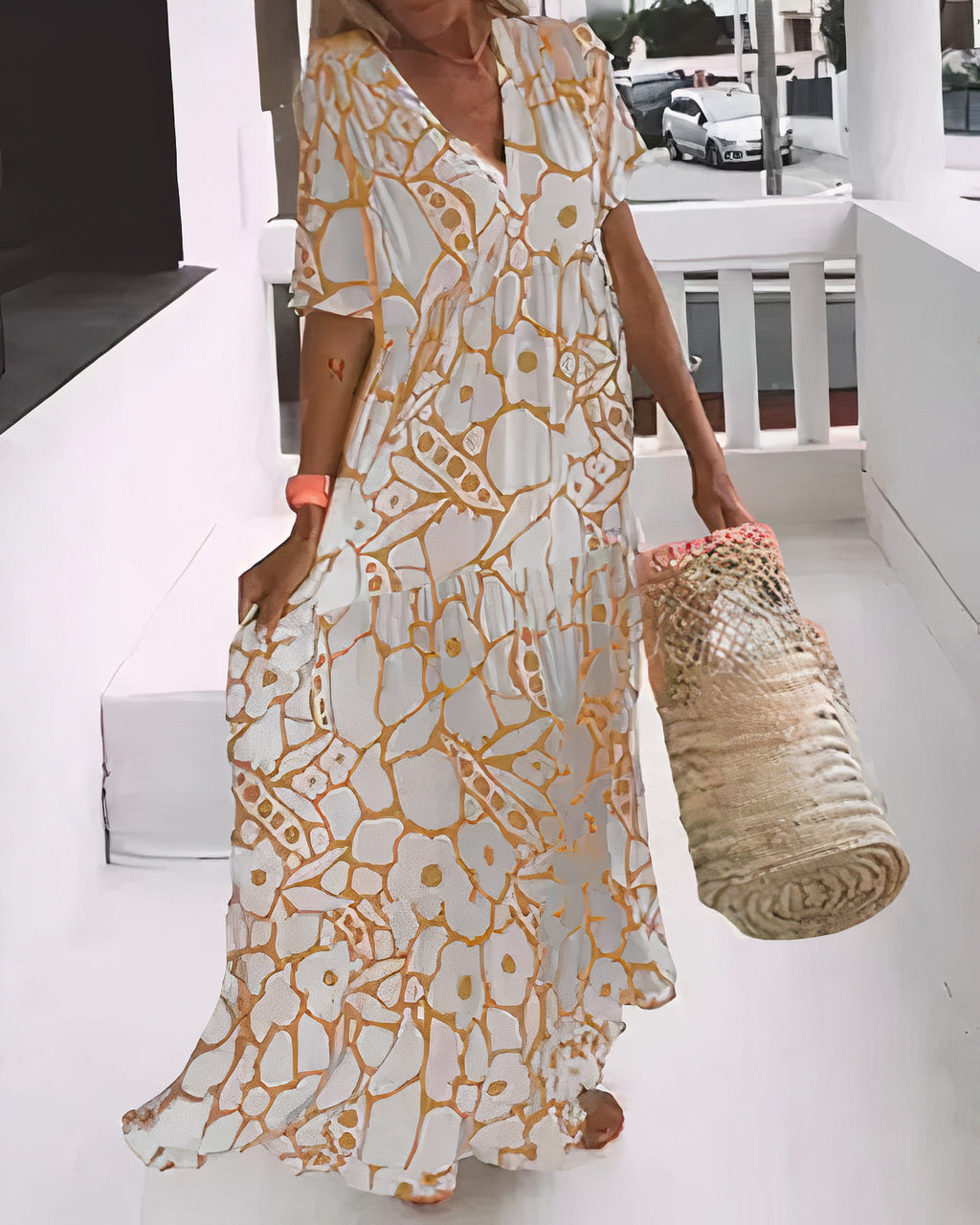 Woman wearing a flowing floral midi dress with a V-neckline while walking outdoors.
