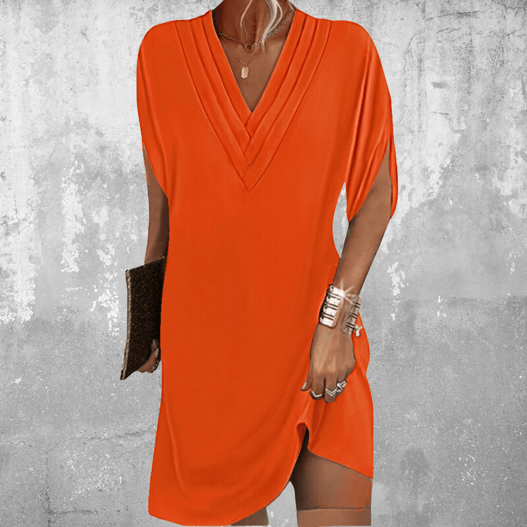 Woman wearing the Robin™ elegant V-neck dress with a relaxed straight silhouette at an evening occasion.
