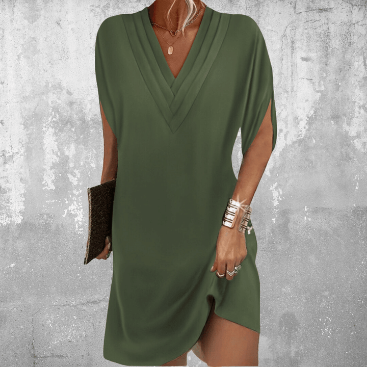 Woman wearing the Robin™ elegant V-neck dress with a relaxed straight silhouette at an evening occasion.