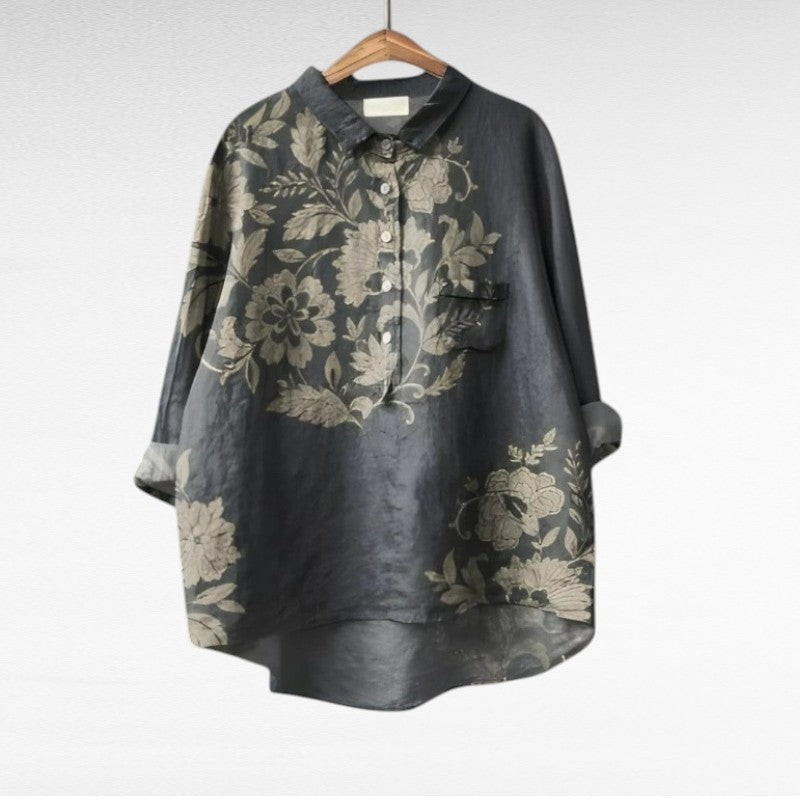 A woman wearing an elegant patterned summer blouse with a fluttering cut, styled with pants.