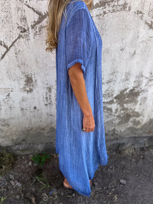 Woman wearing the Andrea™ flowing V-neck dress with short sleeves, standing relaxed in warm sunlight.