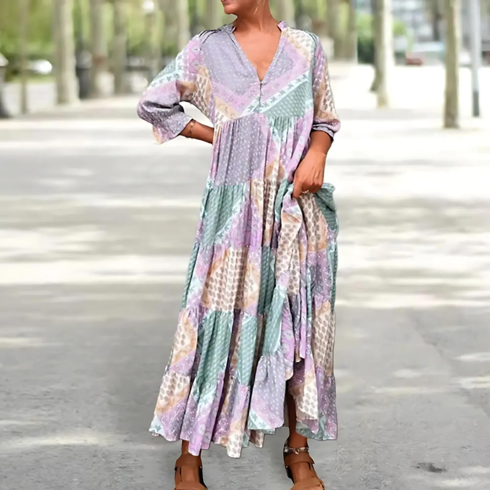 Woman in the Manon patchwork print maxi dress with a V-neckline, standing relaxed in soft summer light.