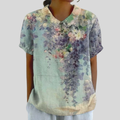 A woman wearing a refined floral top with an elegant collar while out for coffee with friends.