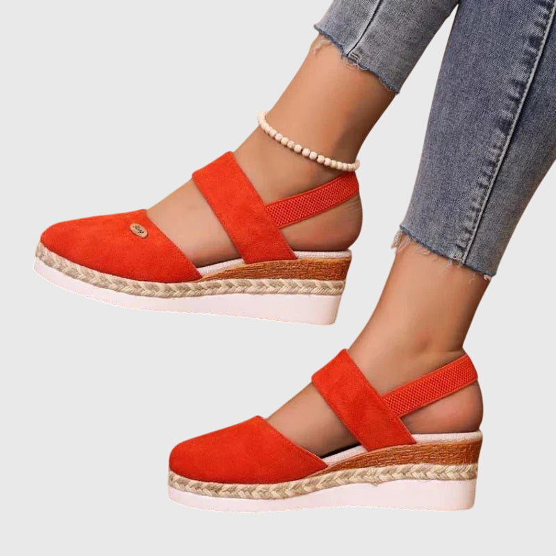 Black closed-toe wedge espadrilles with a wide stretch strap and a braided-trim platform wedge.