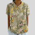 A woman wearing a timeless floral top with an elegant collar and gently flowing shape.