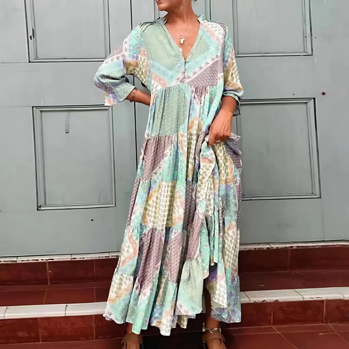 Woman in the Manon patchwork print maxi dress with a V-neckline, standing relaxed in soft summer light.