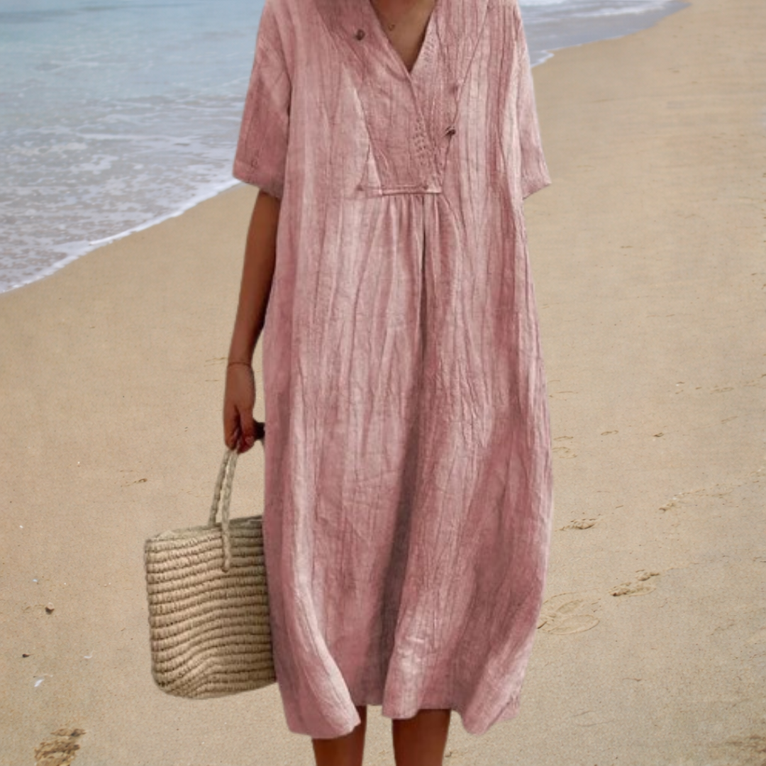A woman wearing a light, solid-coloured summer dress with a relaxed, flowing shape.