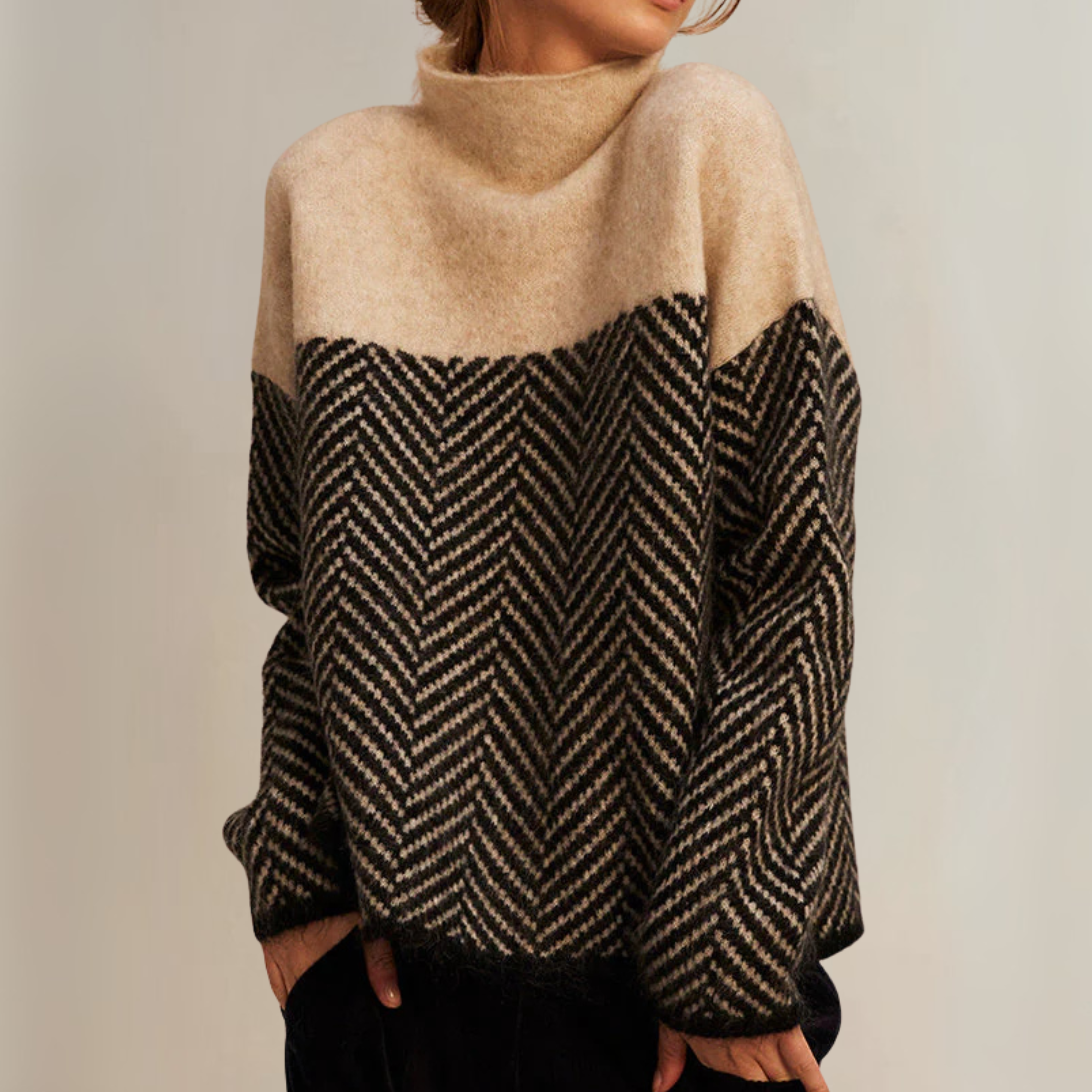 A woman wearing a zigzag-pattern funnel neck sweater styled elegantly for an fall day out.