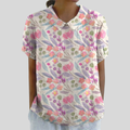A woman wearing a flowing floral top with a polo collar, looking feminine and relaxed.